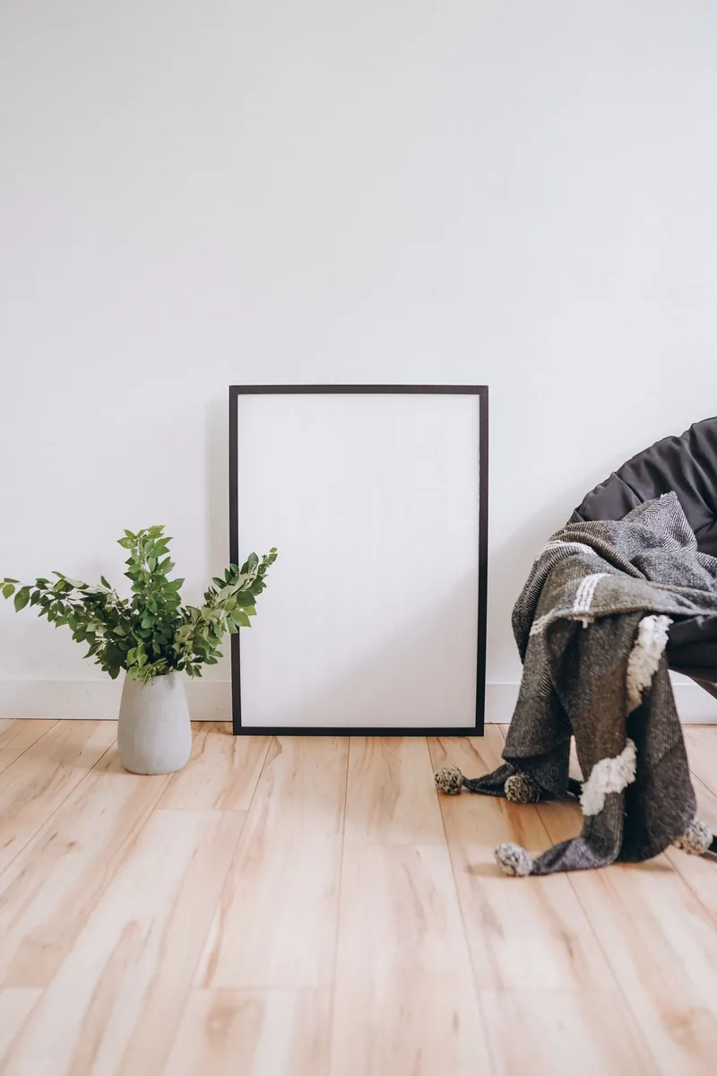 Cozy minimalist interior featuring empty frame, hardwood flooring