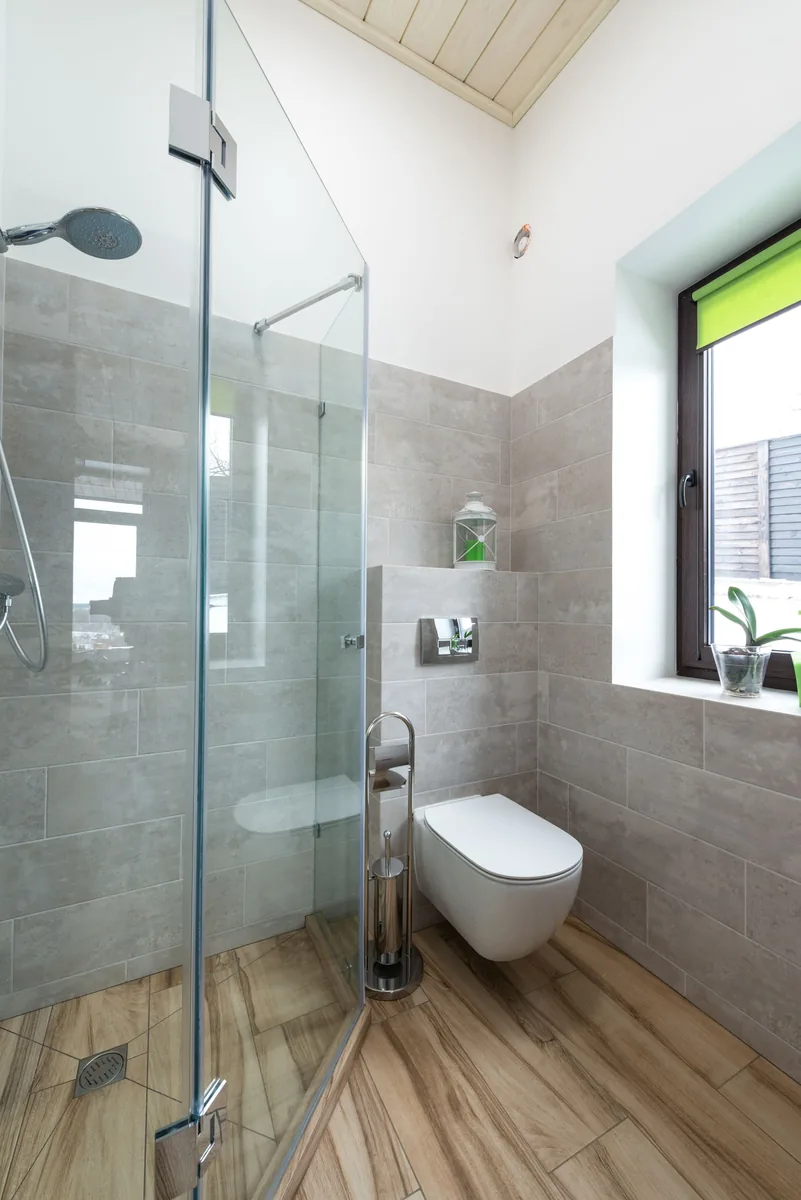 Contemporary bathroom design featuring glass sh, luxury vinyl plank flooring