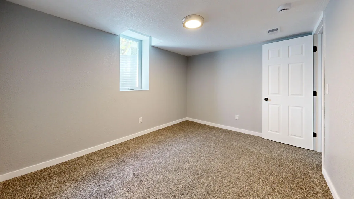 Empty room featuring beige carpet white door window