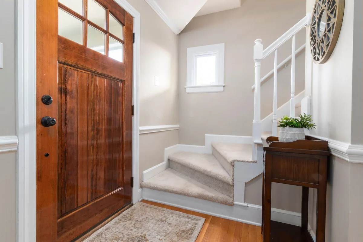 Cozy modern home entrance featuring wooden door, stair flooring